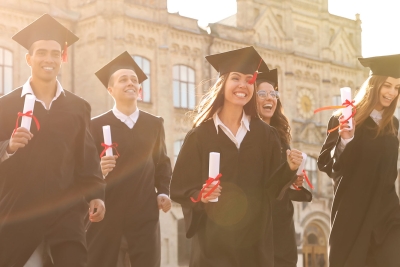 Photo of college graduates walking with their diplomas
