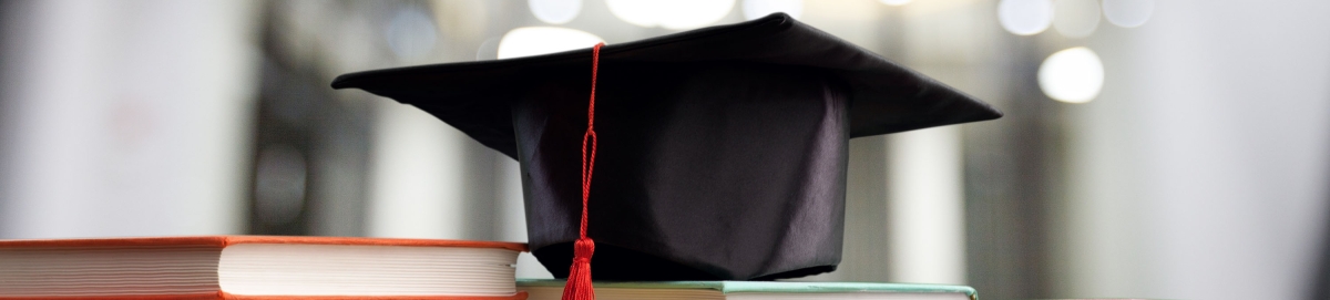 Photo of college graduate cap on top of books