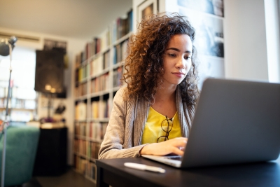 Photo of female college student writing on her laptop