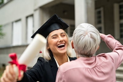 A female graduate hugging parent