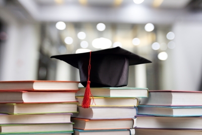 Photo of college graduate cap on top of books