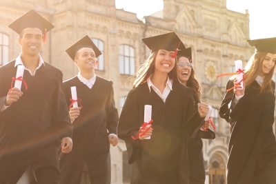 Photo of college graduates walking with their diplomas