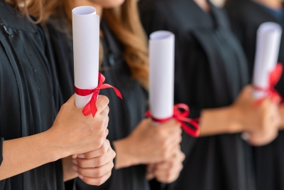 Photo of college graduates holding diplomas