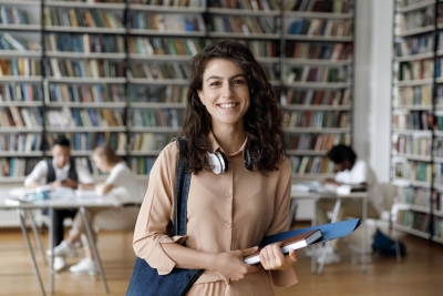 Smiling female college student in the library